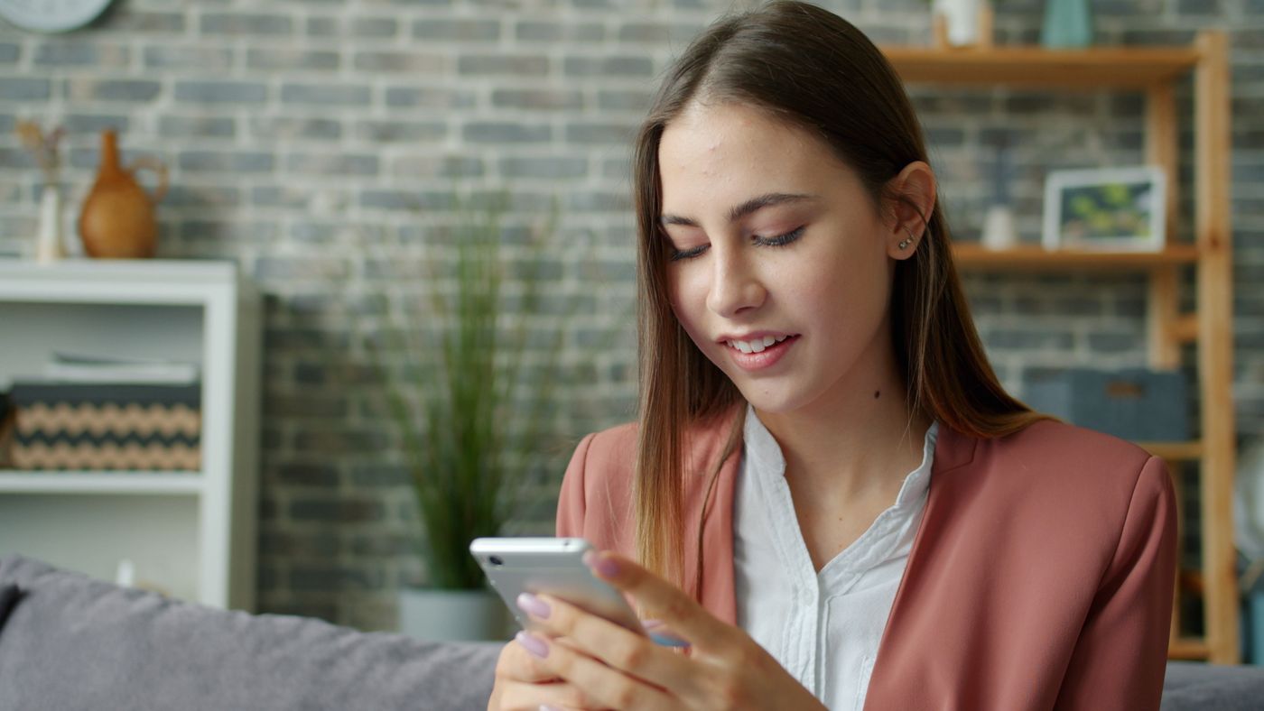 A woman using her smartphone while sitting at home