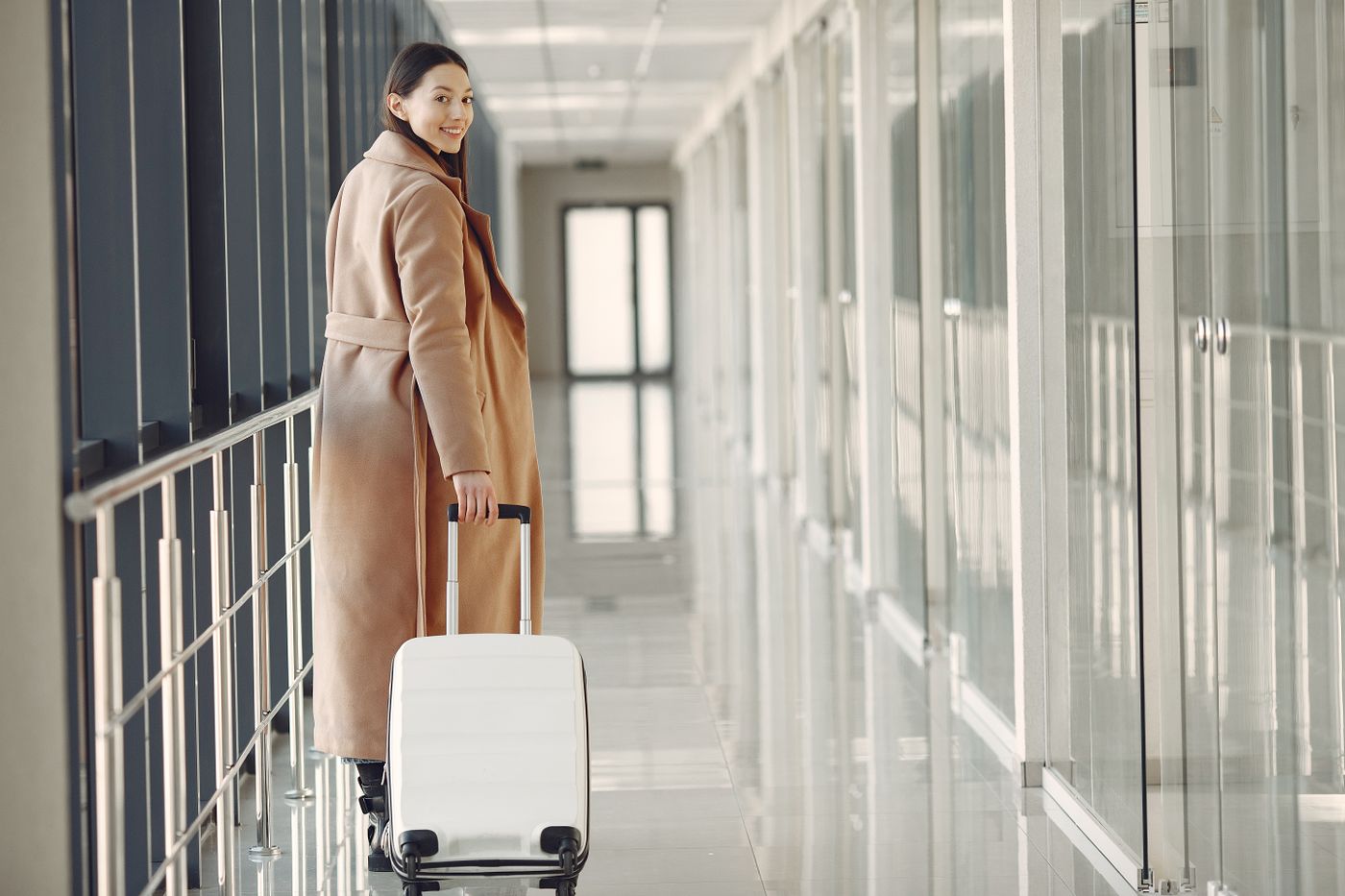 A traveller with a suitcase walking through an airport terminal