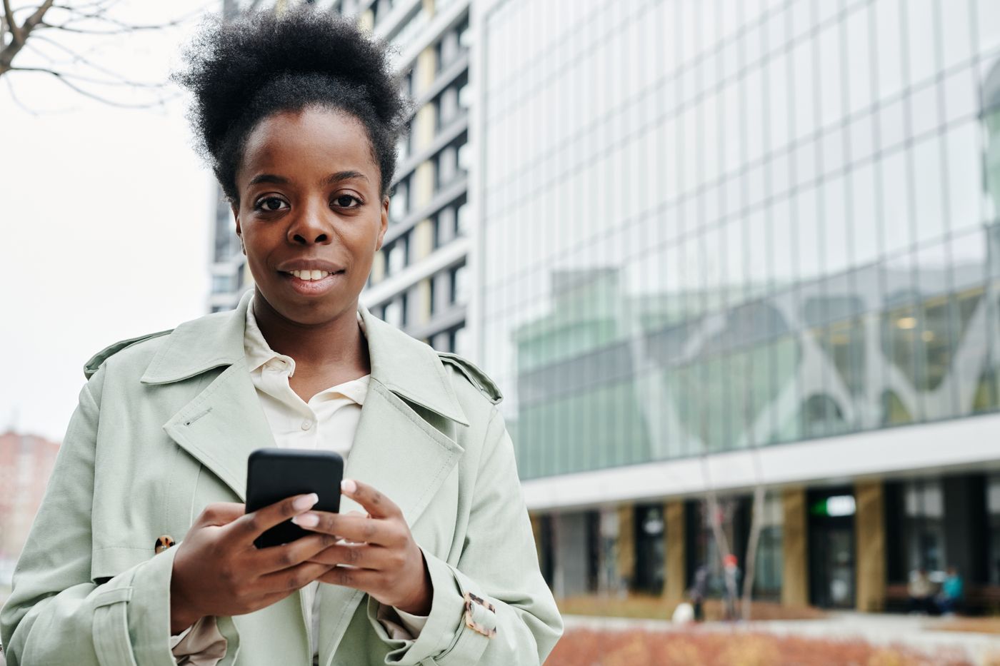 A woman using her phone in a modern city